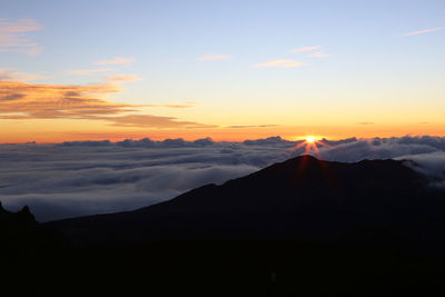 Scenic view of silhouette mountain against cloudscape during sunset