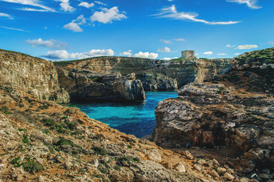 Rock formations by sea against sky