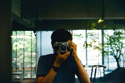 Man photographing through window