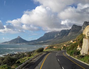 Road by mountains against sky
