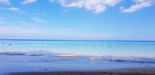 Scenic view of beach against blue sky