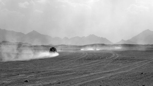 Man riding motorcycle on land against sky