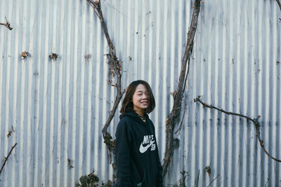 Portrait of teenage girl standing against plants