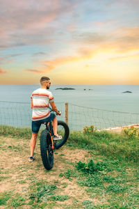 Man riding a fat bike looking at the sea from the coast