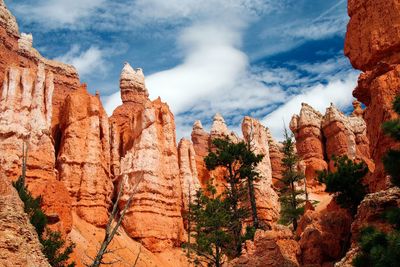 Panoramic view of rocks and trees against cloudy sky