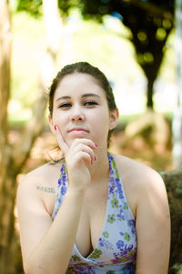 Portrait of confident young woman sitting at park