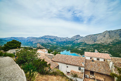 Scenic view of townscape and mountains against sky