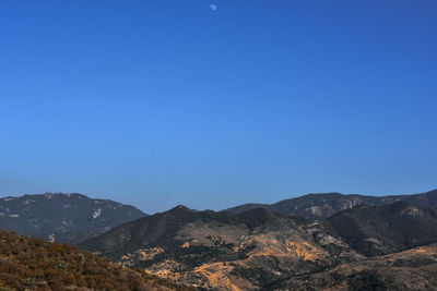 Scenic view of mountains against clear blue sky