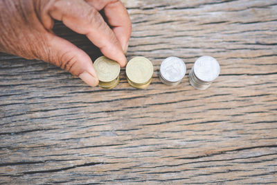 Cropped hand stacking coins on wooden table