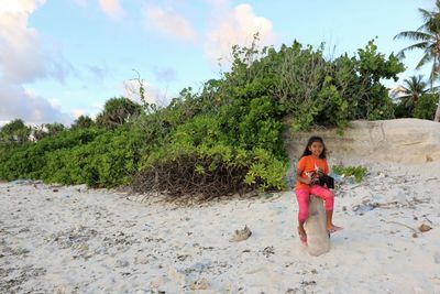 Portrait of woman on beach against sky
