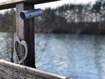 Close-up of bicycle by railing against lake