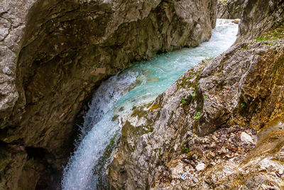 High angle view of stream flowing through rocks