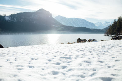 Scenic view of lake and snowcapped mountains against sky