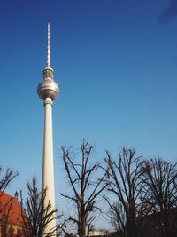 Low angle view of communications tower against blue sky