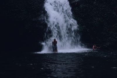 Man splashing water in waterfall