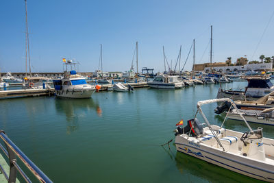 Sailboats moored in harbor