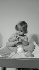 Cute baby girl sitting on bed