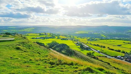 Scenic view of field against cloudy sky