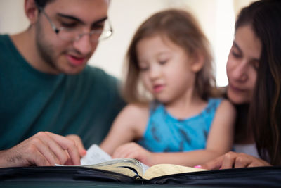 Portrait of a smiling young woman reading book