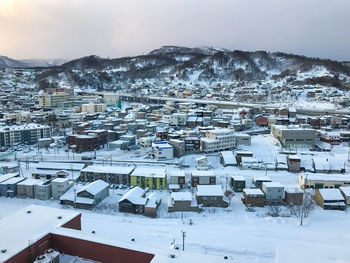 High angle view of snow covered houses in city