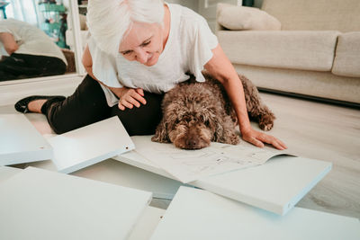 Woman with dog working on wood at home