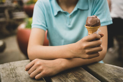 Midsection of boy sitting on ice cream