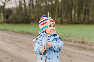 Girl in warm clothing standing on land