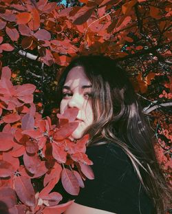 Full frame shot of woman with red leaves