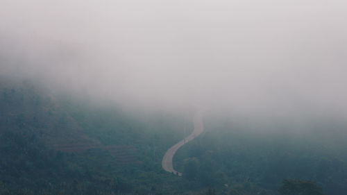 Scenic view of landscape against sky during foggy weather