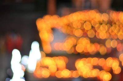 Defocused image of illuminated lights in city at night