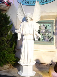 Statue of angel against building