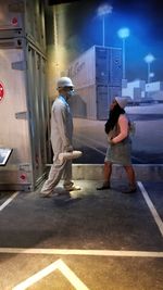 Side view of man standing on street in city