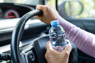 Cropped hand of man holding water bottle