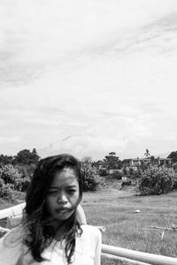 Portrait of smiling woman on field against sky