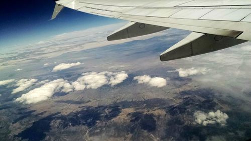 Cropped image of airplane flying over landscape