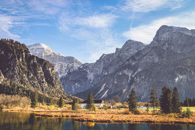 Scenic view of lake by mountains against sky