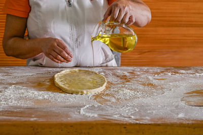 Midsection of woman holding cookies on table