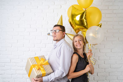 Portrait of a smiling young woman holding balloons