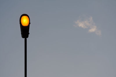 Low angle view of illuminated street light against sky