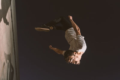 Full length of man jumping against sky at night