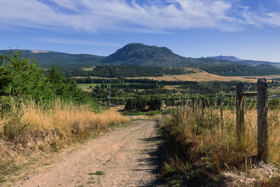 Road leading towards mountains against sky