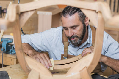 Carpenter making chair in workshop