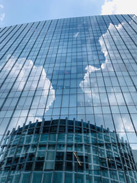 Low angle view of glass building against sky