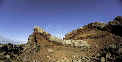 Low angle view of rocky mountain against sky