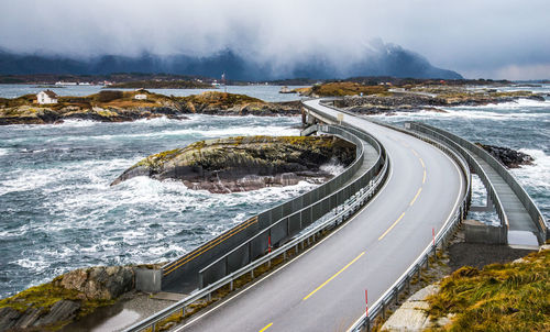 Road by sea against sky during winter