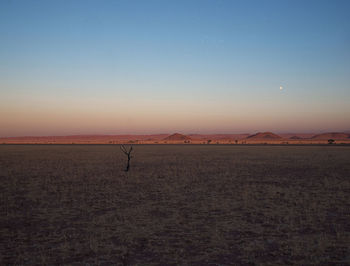 Scenic view of desert against sky during sunset