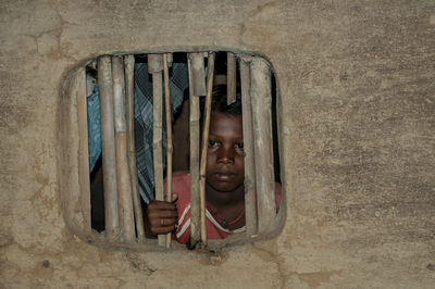 Portrait of cute boy in window of building