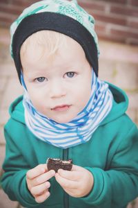 Close-up portrait of boy holding cookie