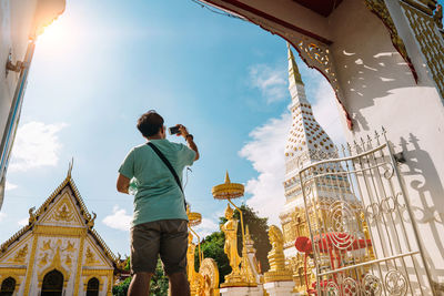 Rear view of man photographing temple