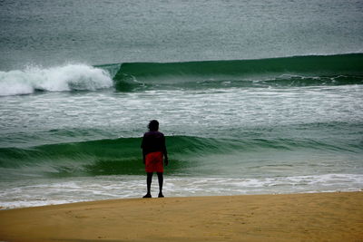 Rear view of man standing on beach